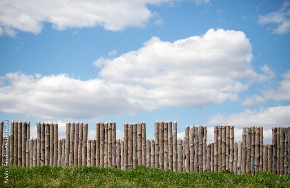 Wooden palisade against the sky, loopholes of the fortress.