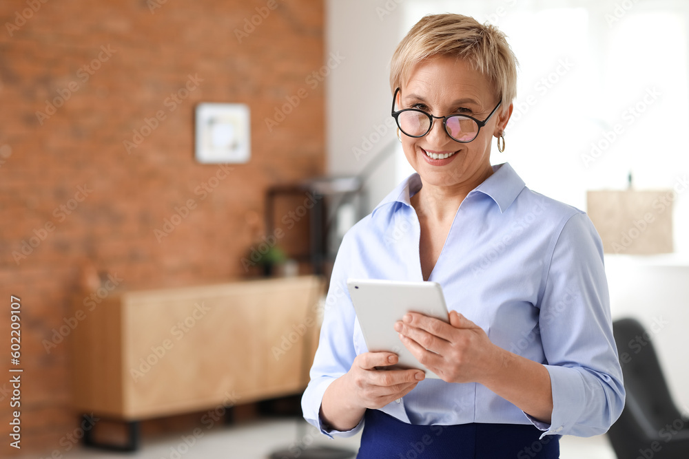 Mature psychologist with tablet computer in office