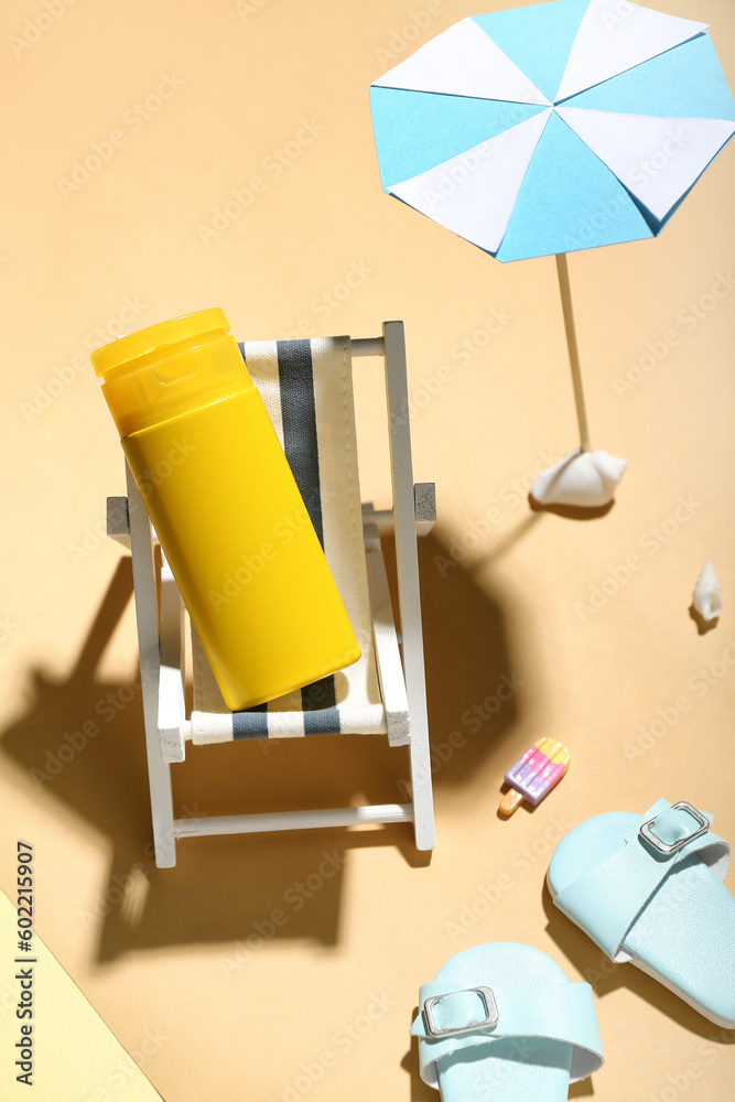 Creative composition with miniature deckchair, umbrella and sunscreen on color background