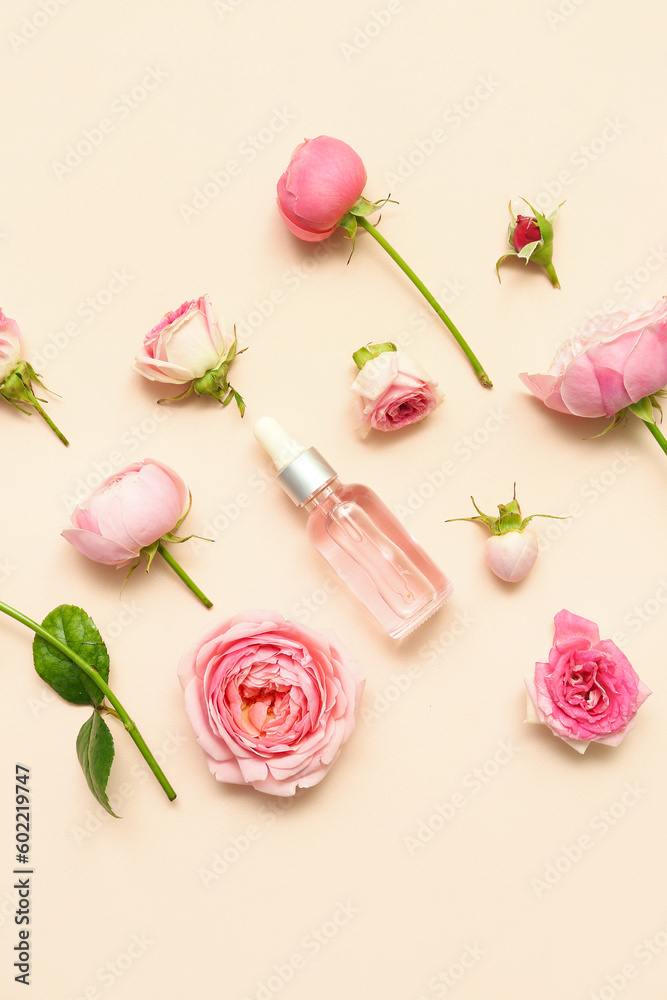 Bottle of cosmetic oil with rose extract and flowers on beige background