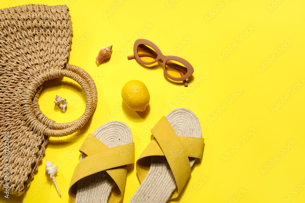 Sandals with beach accessories on  yellow background