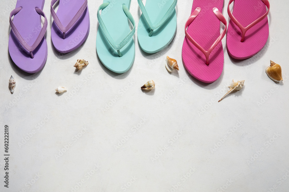 Colorful flip flops with seashells on white background