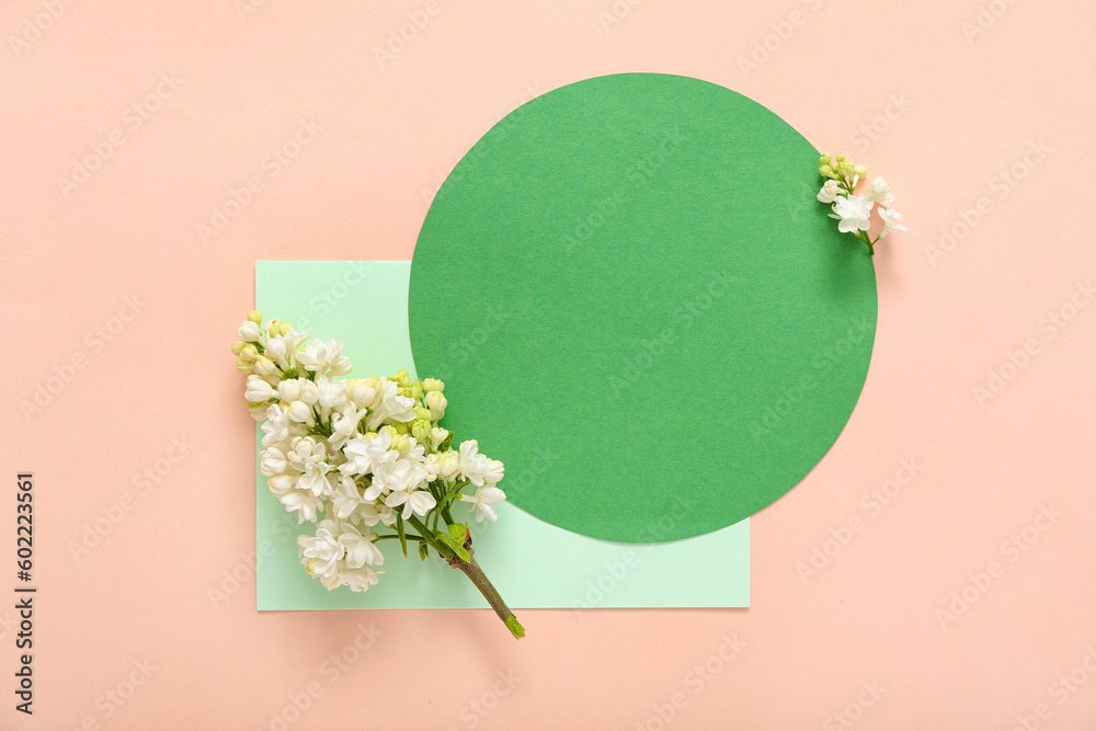 Blank cards and beautiful lilac flowers on pale pink background