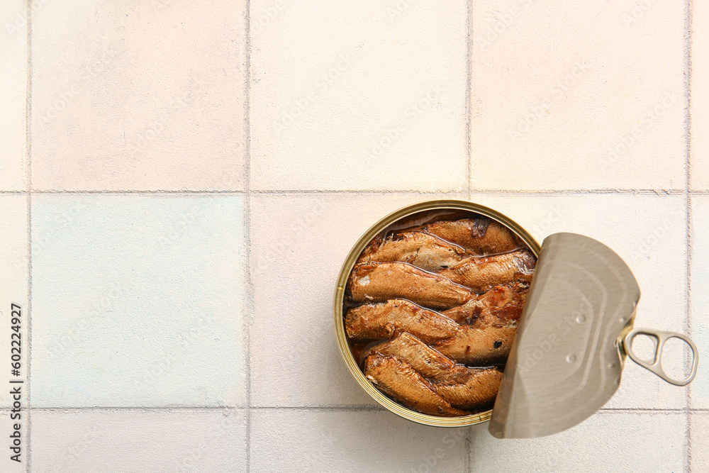 Canned smoked sprats on white tile background