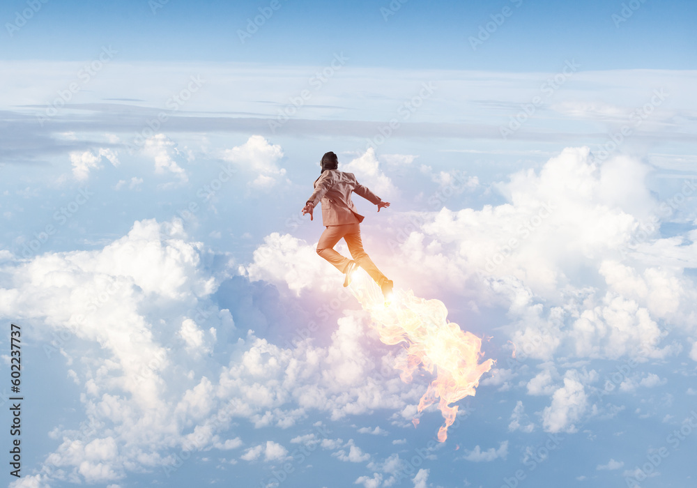 Businessman in suit and aviator hat flying in sky