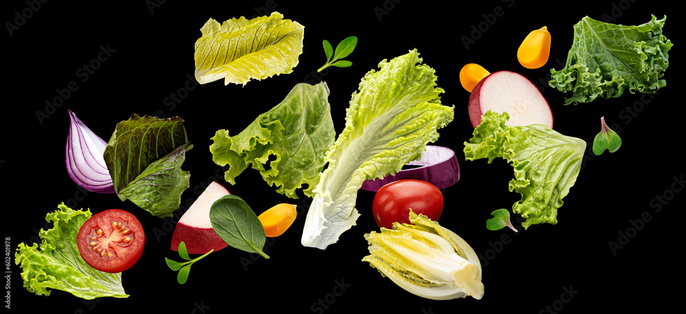 Falling vegetables, salad of bell pepper, tomato and lettuce leaves on black background