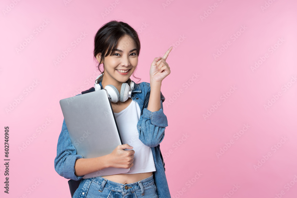 Young Asian woman texting message using mobile phone application on isolated brown background