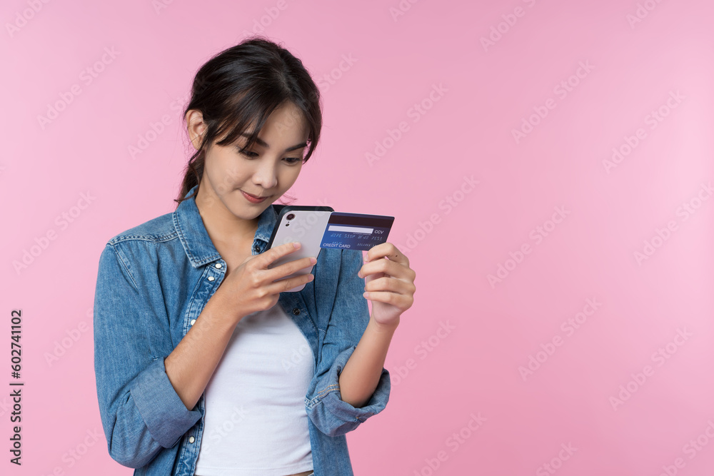 Young beauty Asian woman shopping payment online with credit card on smartphone and she wearing jean