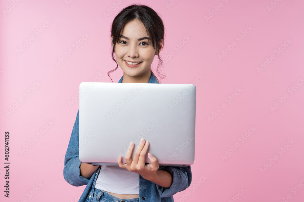 Young Asian college student working with a laptop computer, looking directly at the camera in a stud