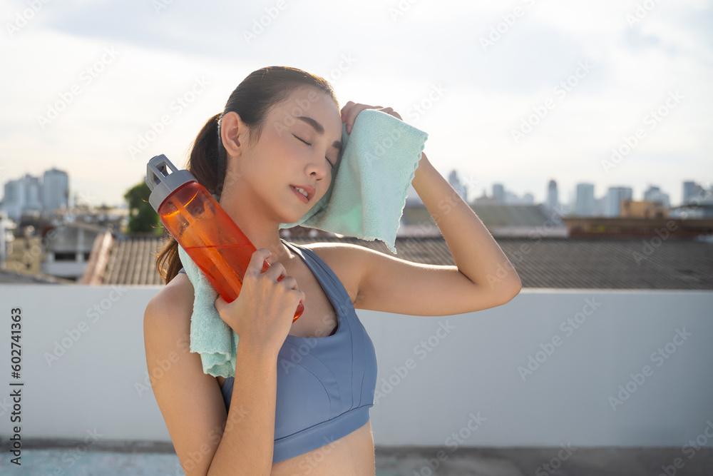 Young Asian woman resting after running exercise.outdoor exercise fitness concept