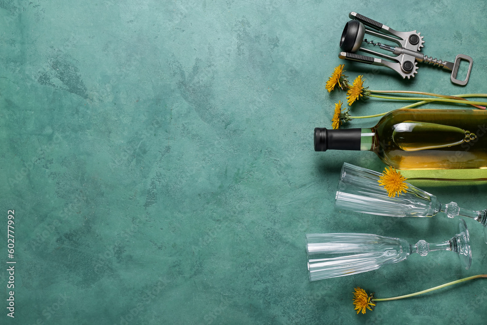 Bottle and glasses of dandelion wine on green background