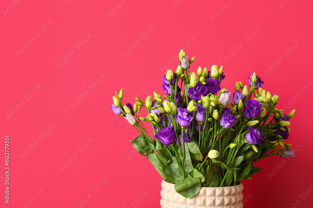 Vase with eustoma flowers on red background