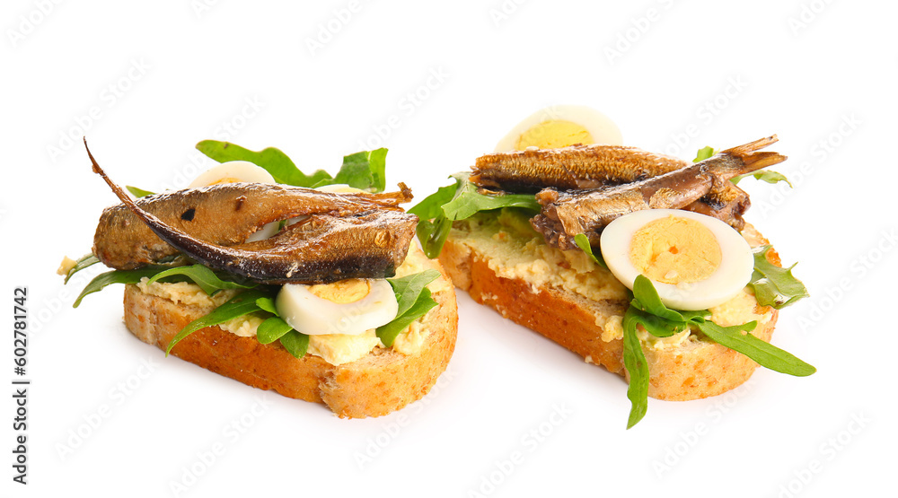 Tasty sandwiches with canned smoked sprats on white background