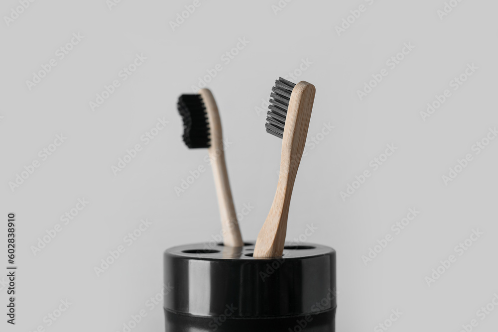 Holder of bamboo toothbrushes on black table