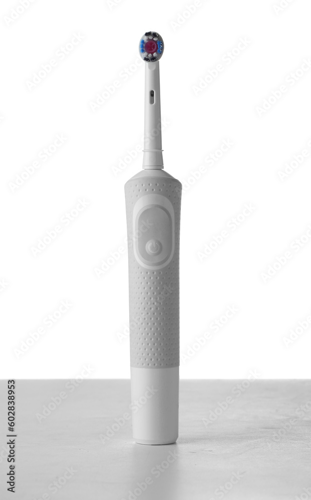 Electrical toothbrush on table against white background