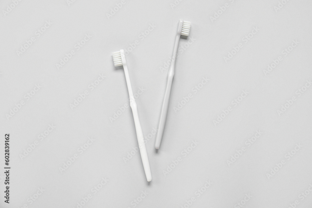 Plastic toothbrushes on grey background