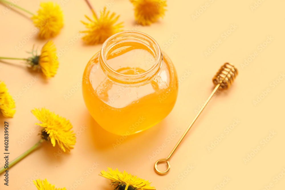 Jar with dandelion honey on orange background