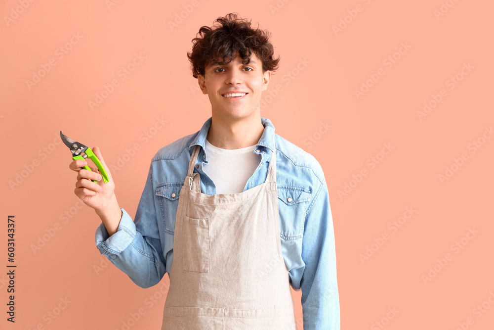 Male gardener with secateurs on pink background