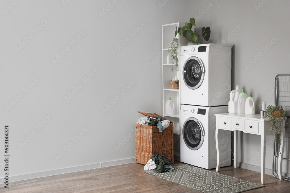 Interior of laundry room with washing machines, table and basket