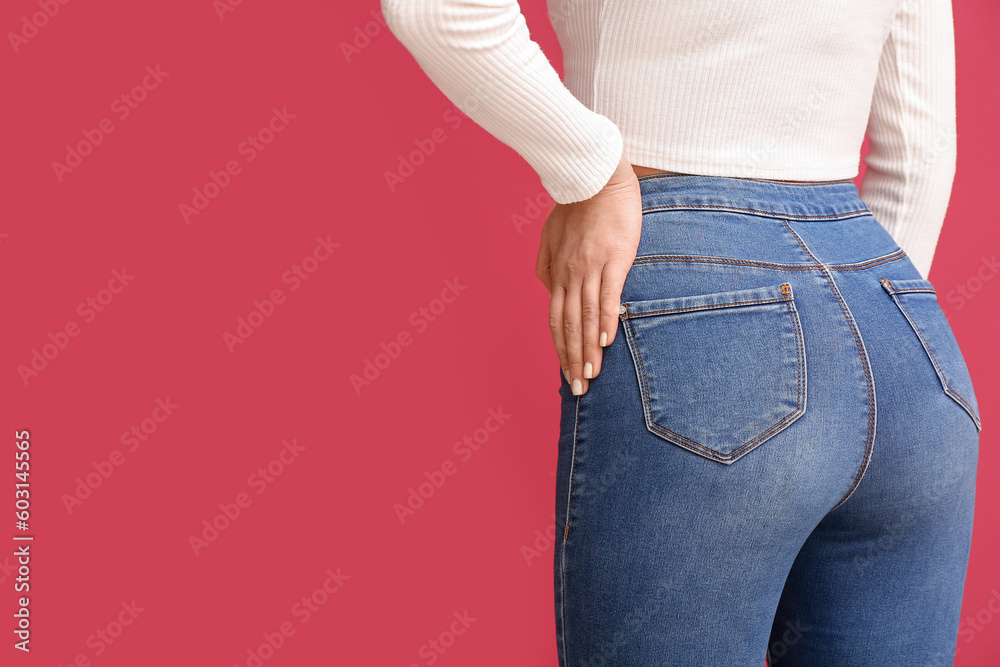 Young woman in stylish jeans on red background, closeup