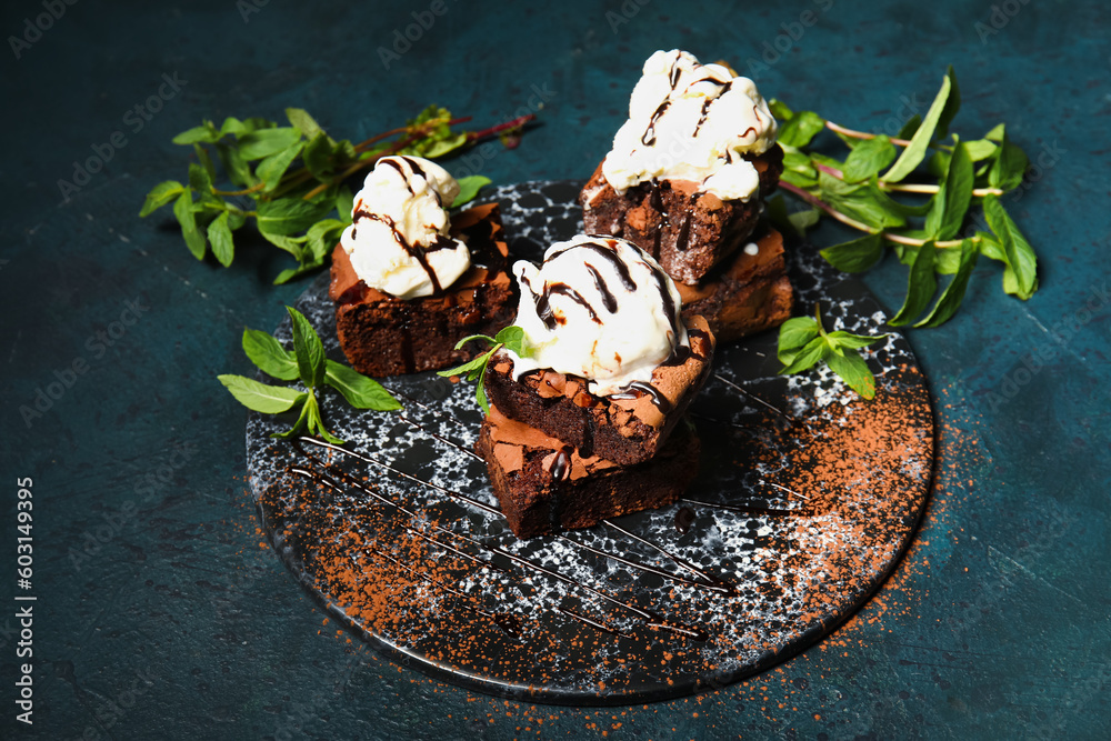 Board with pieces of tasty chocolate brownie and ice cream on dark background