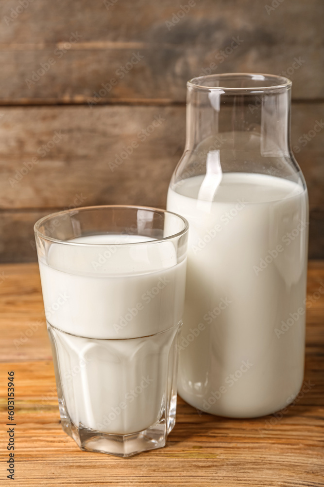 Bottle and glass of fresh milk on wooden background