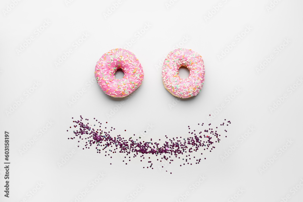 Smile made of donuts with confetti on white background