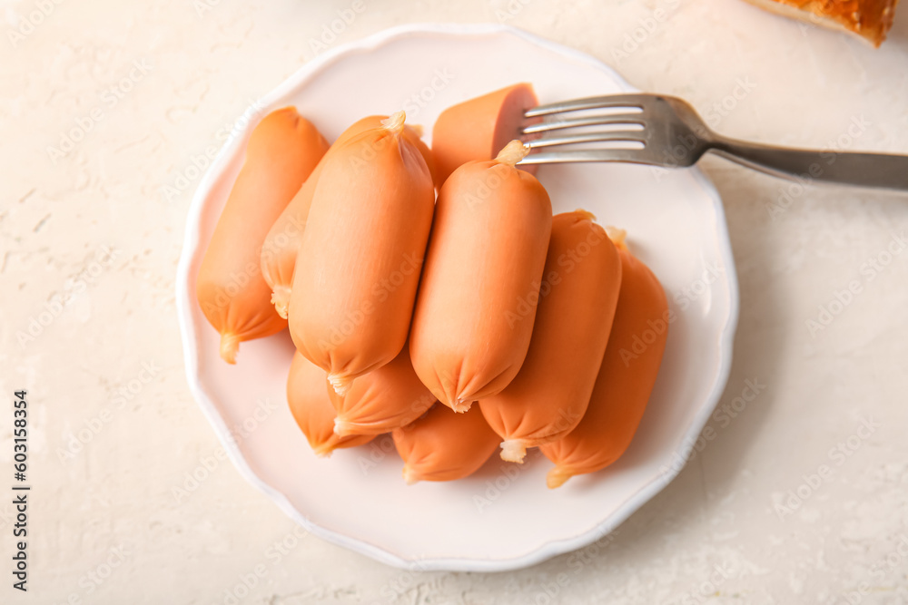 Plate of tasty boiled sausages on grey background