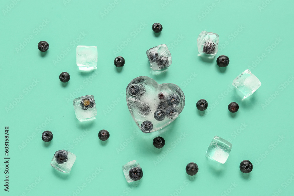 Ripe blueberry frozen in ice and fresh berries on blue background