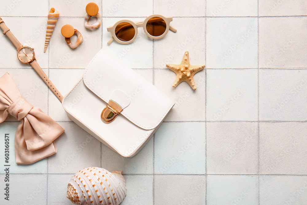 Stylish bag and different accessories on white tile background