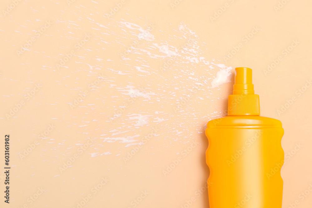 Bottle of sunscreen cream on pale orange background