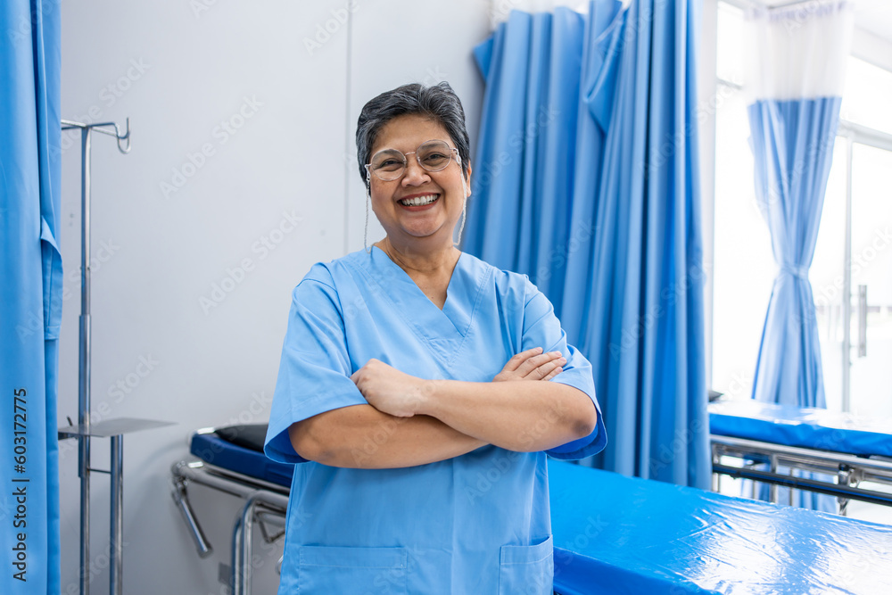 Portrait of Senior elderly female nurse standing in the hospital ward. 