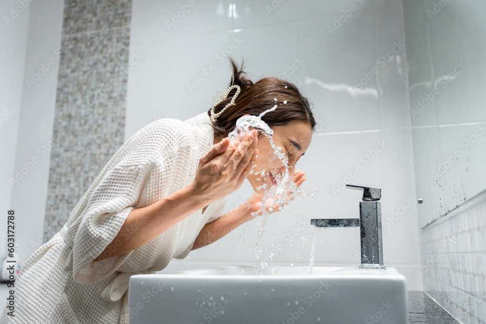 Asian beautiful woman washing her clean face with facial foam and water.