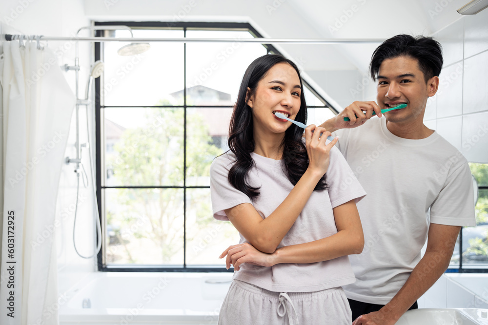 Asian new marriage couple brushing teeth together in bathroom at home. 