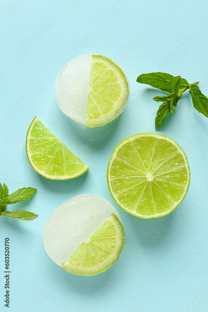 Fresh lime and slices frozen in ice with mint on blue background