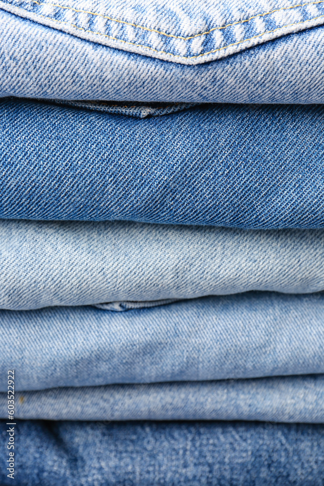 Different folded denim jeans as background, closeup