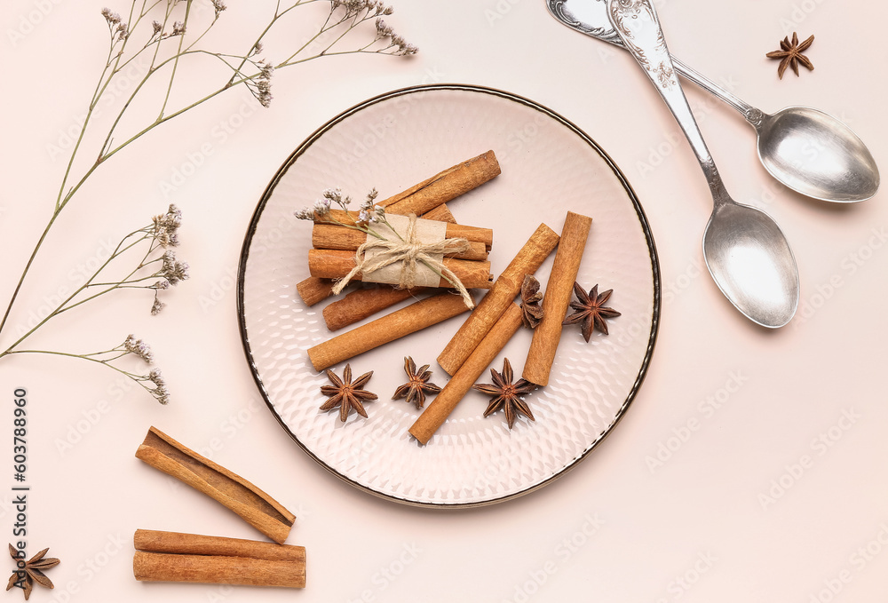 Composition with cinnamon sticks, anise stars, spoons and dried flowers on light background