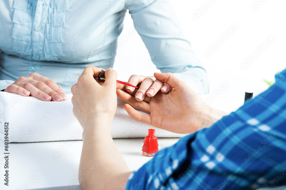 Manicurist working with clients nails at table