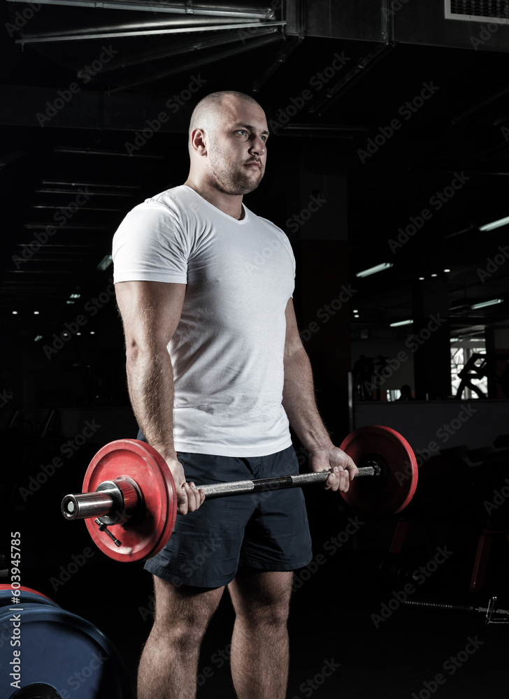 Male athlete lifts the barbell