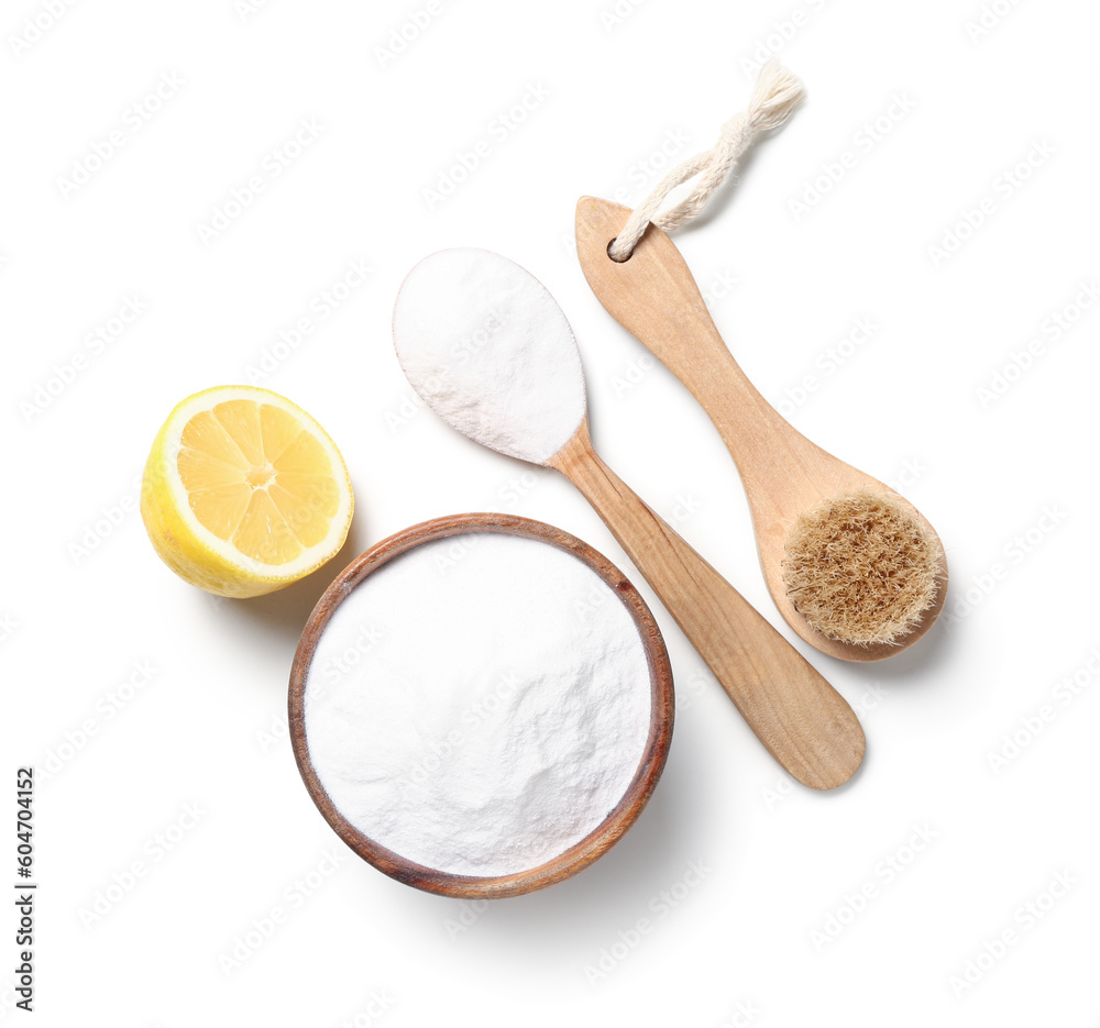 Bowl of baking soda, cleaning brush and lemon on white background