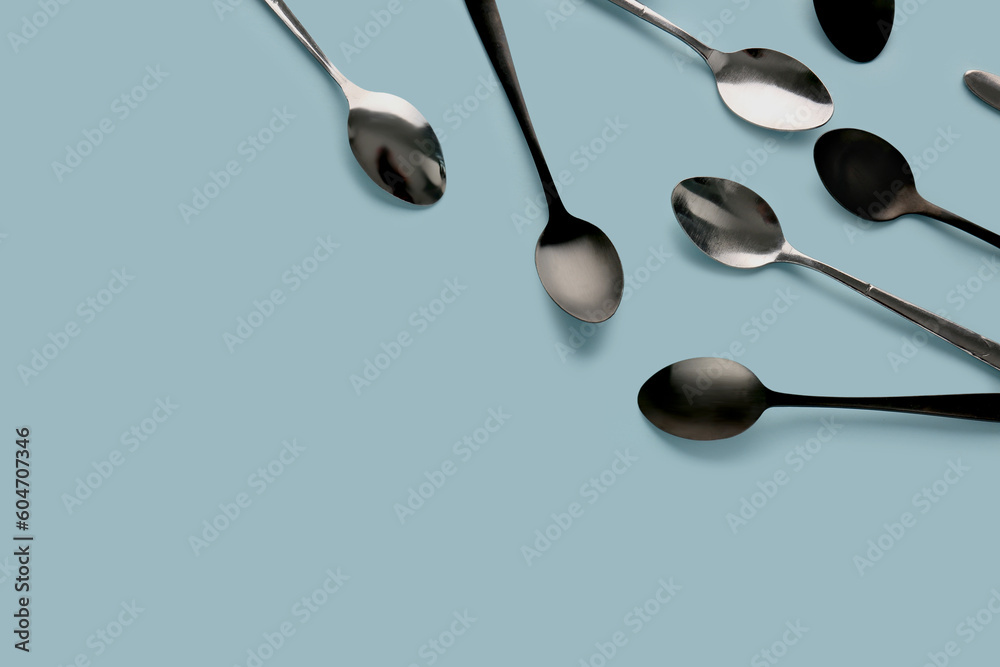 Stainless steel spoons on blue background