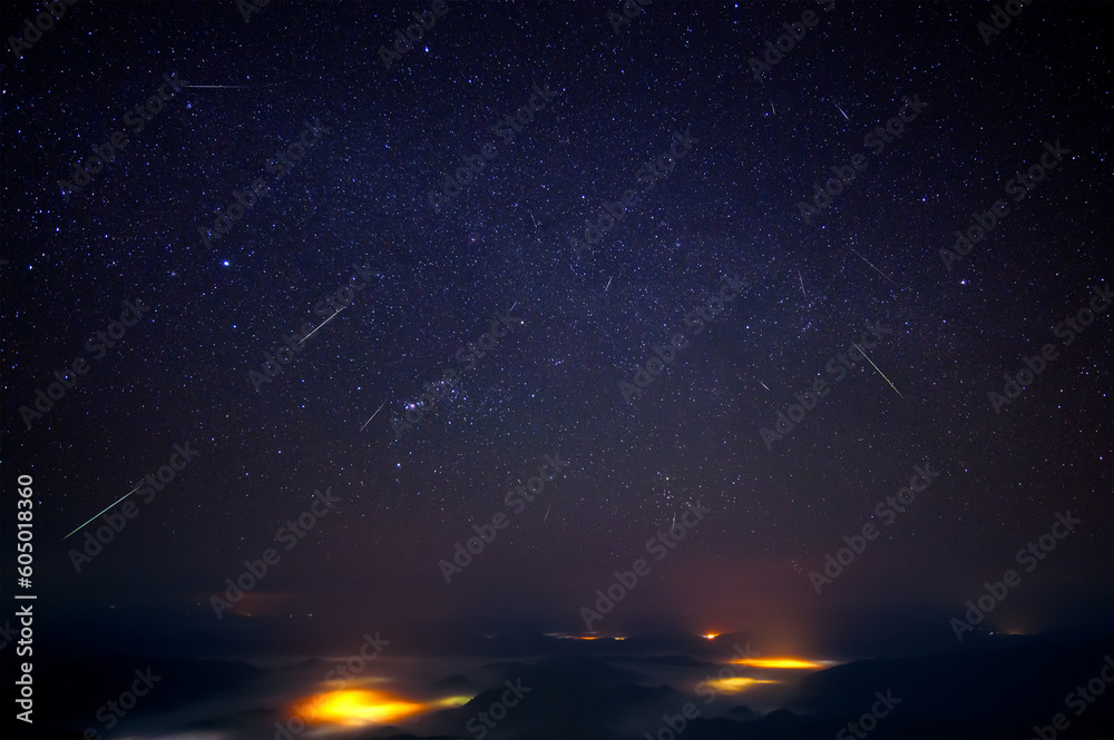 Night landscape of misty mountains with the Geminid meteor shower on midnight of 13 December  2021