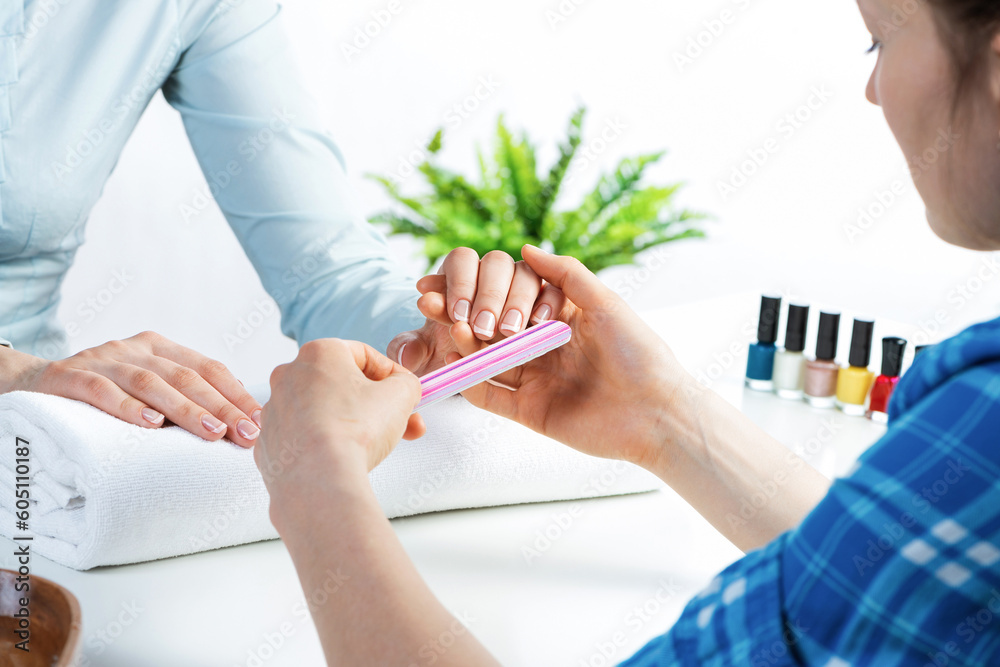 Manicurist using nail file and create nails shape