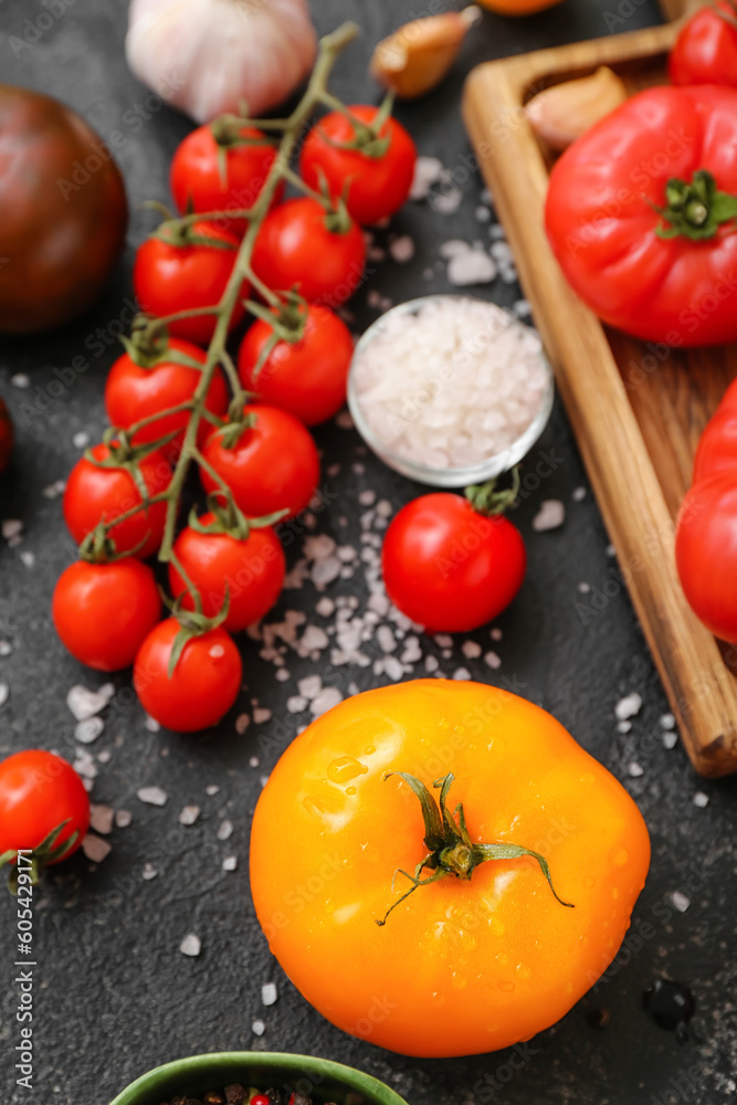 Different fresh tomatoes on black background