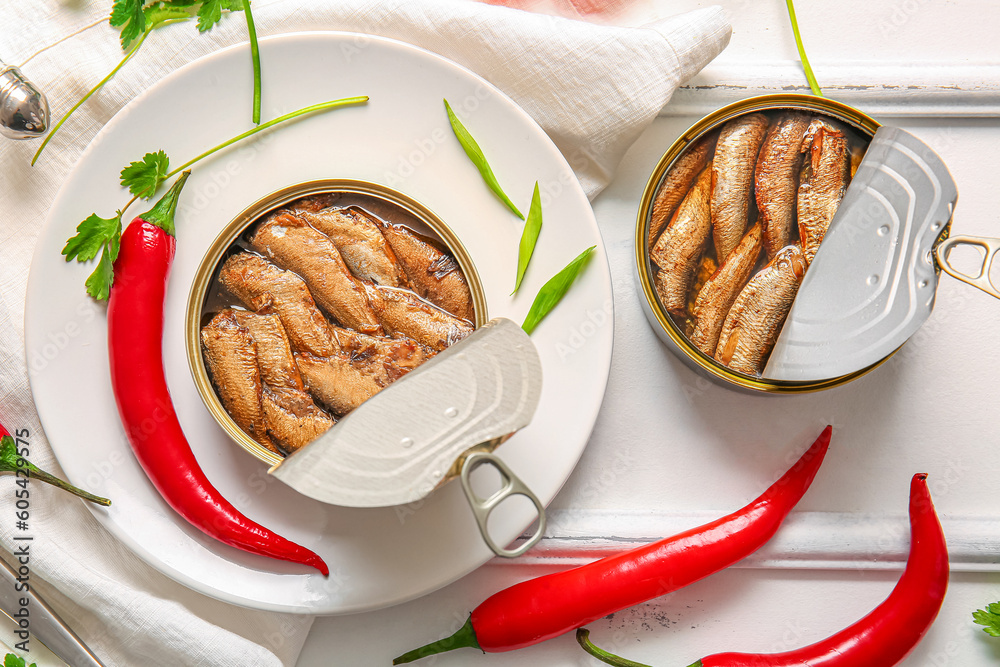 Plate of canned smoked sprats with parsley on white wooden  background