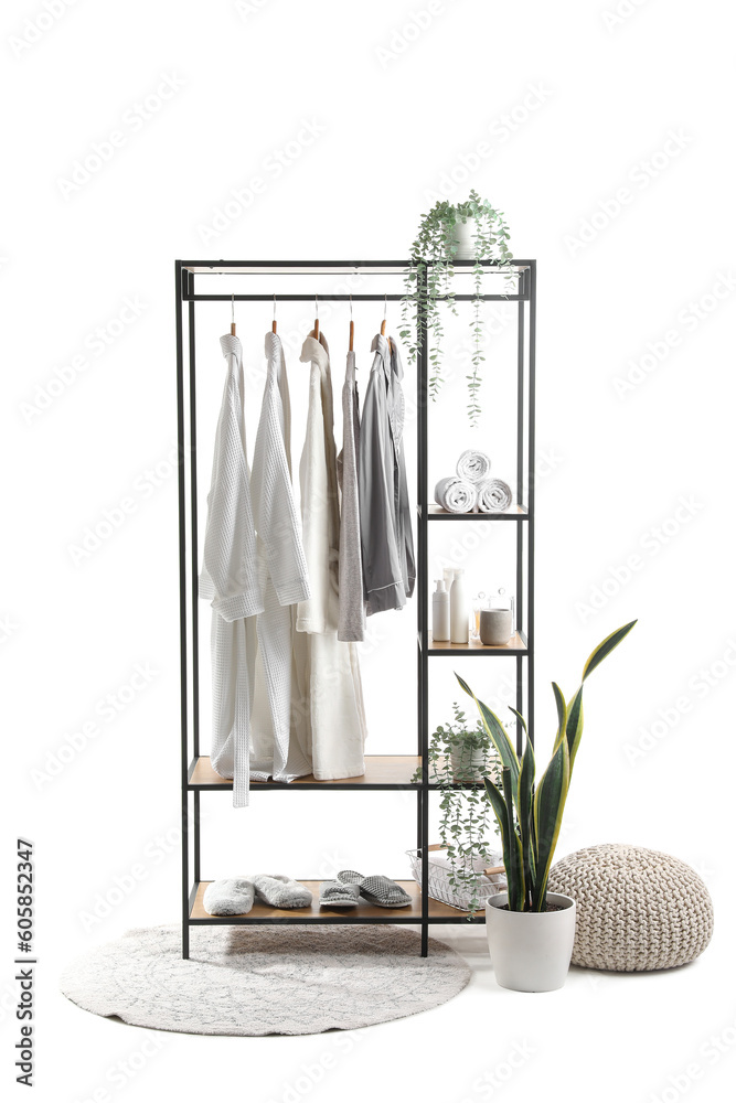 Shelving unit with pajamas and bath accessories on white background