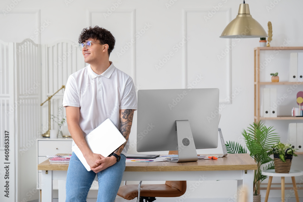 Male graphic designer with laptop in office