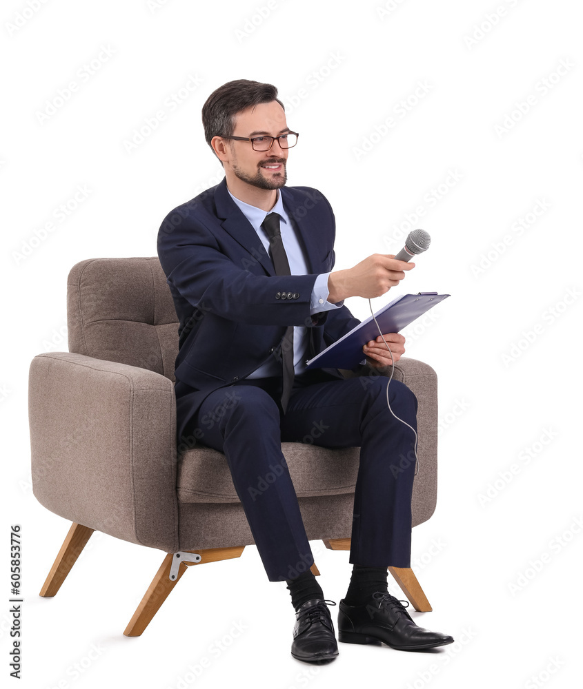 Male journalist with microphone and clipboard in armchair on white background