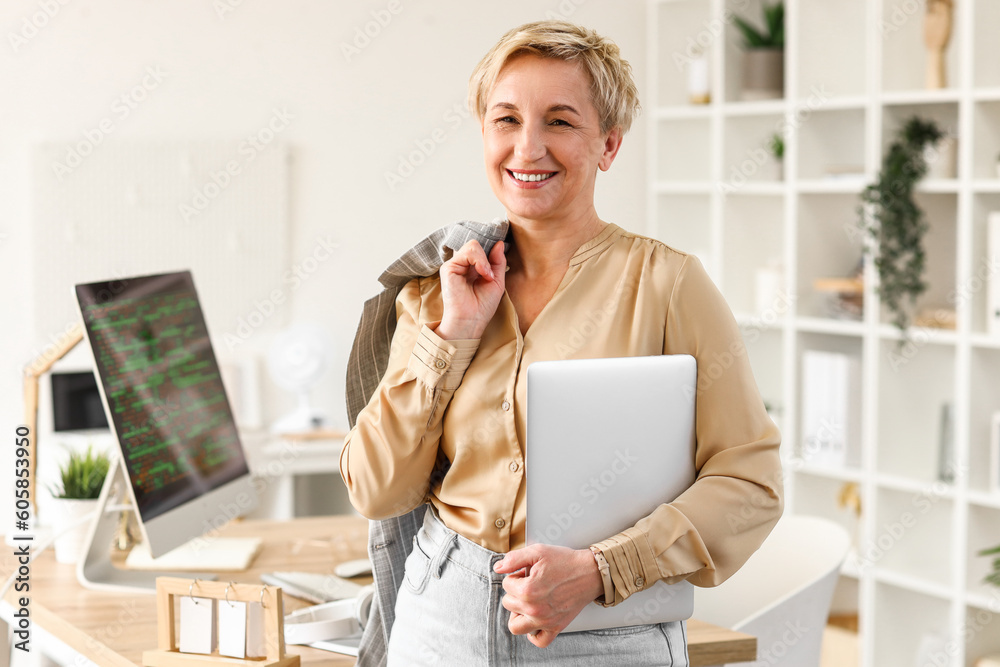 Mature female programmer with laptop in office