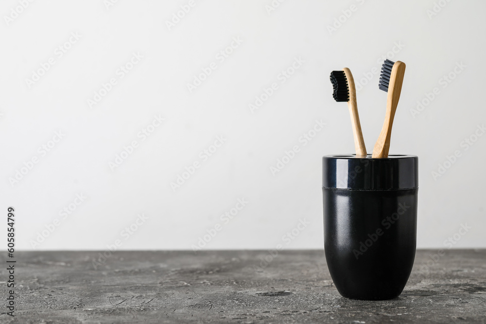 Holder of bamboo toothbrushes on black table